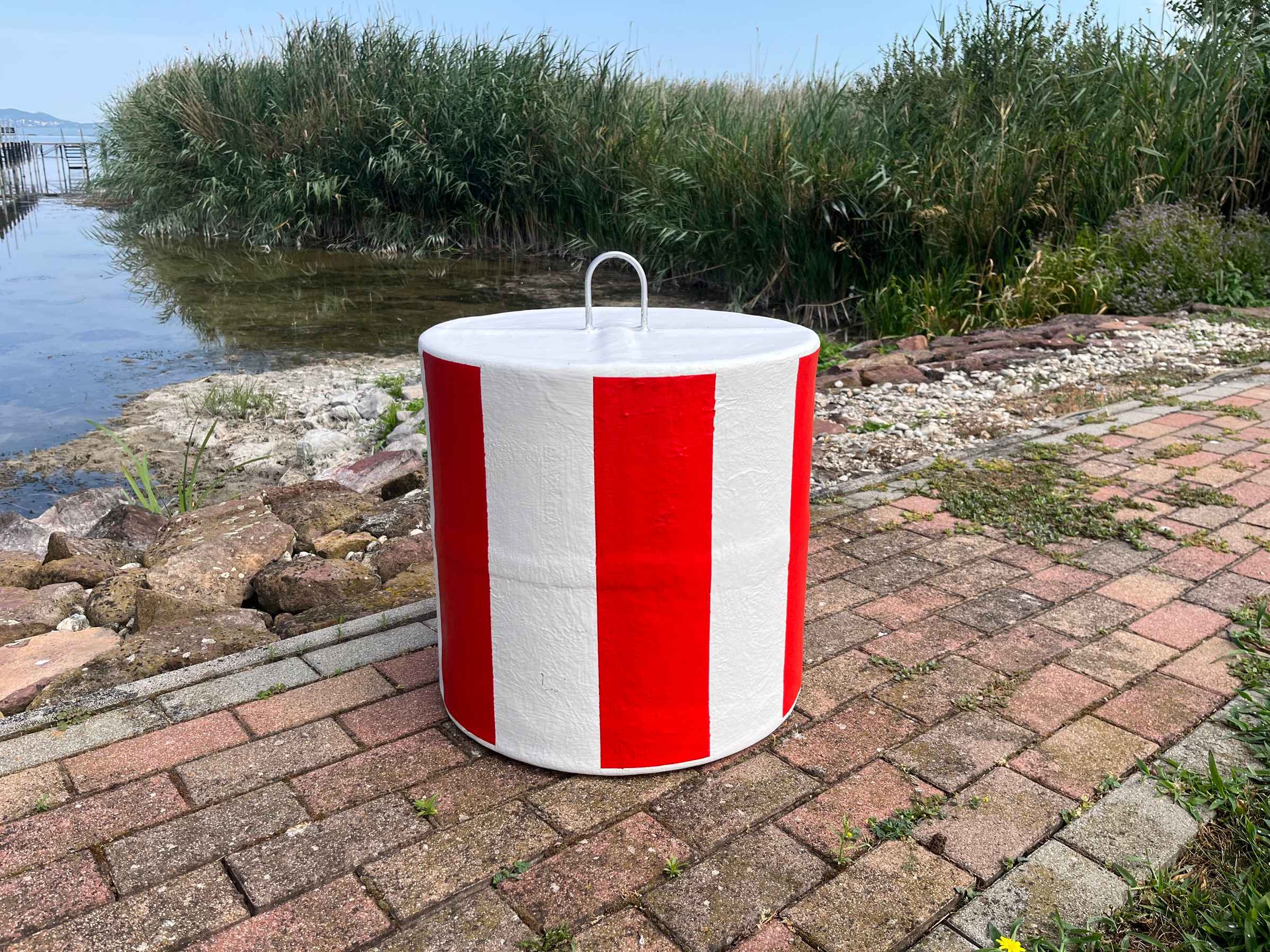 Piros-fehér csíkos strandbója a Balaton partján